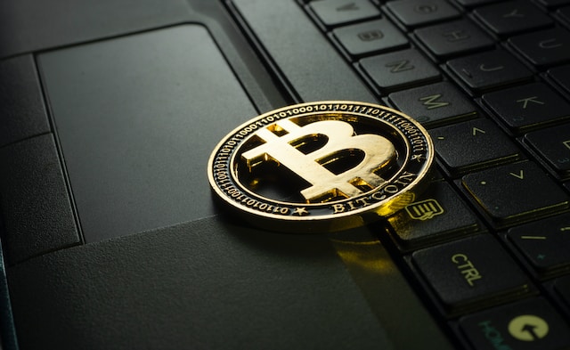 A bitcoin on top of a laptop